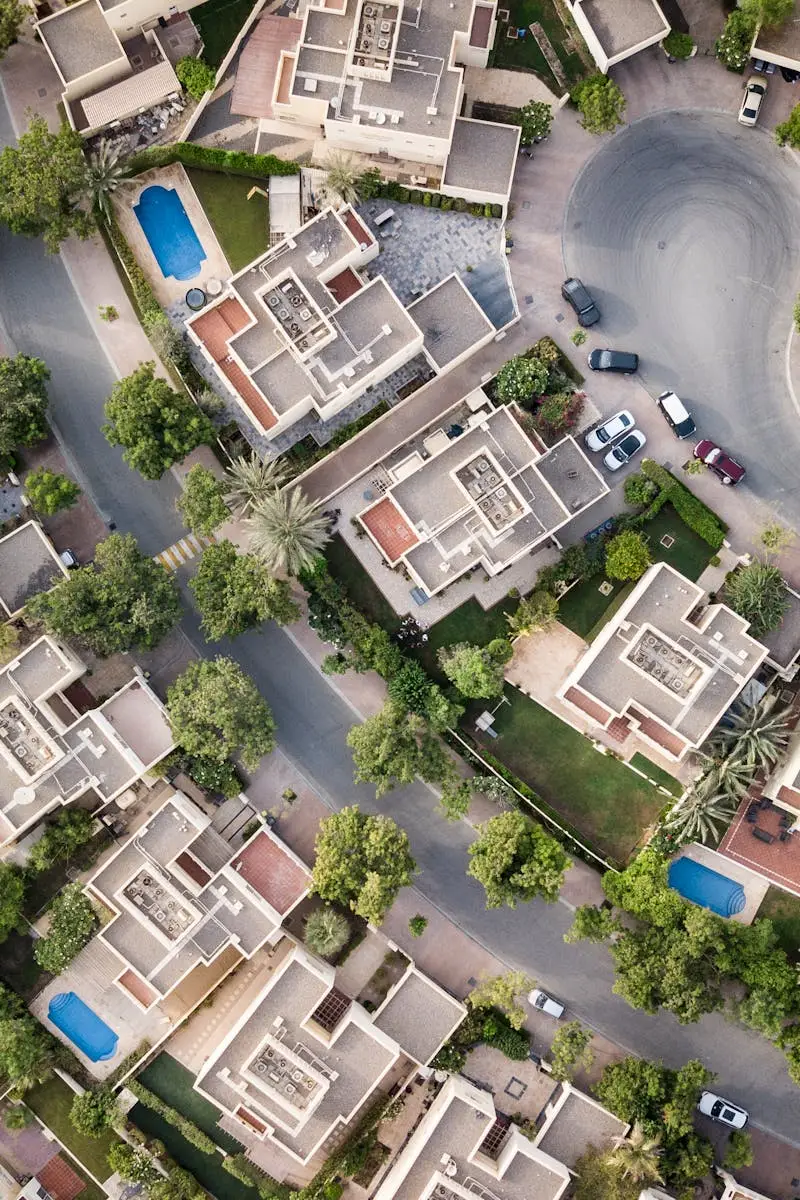 Explore a stunning aerial view of a residential area in Dubai with lush greenery and swimming pools.
